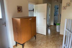 a room with a wooden cabinet and a hallway with a door at Summer in the North of Sweden in Bjurholm
