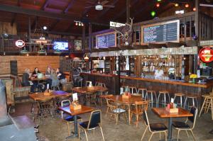 a restaurant with wooden tables and chairs and a bar at Pitchwood Inn in Raymond