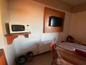 a small room with a microwave on the wall at Condominio Residencial pousada do Serran0 in Gramado