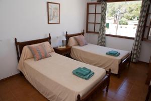 a room with two beds and a window at Apartamentos Llevant in Cala Figuera