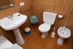 ein Badezimmer mit einem weißen Waschbecken und einem WC in der Unterkunft Apartamentos Llevant in Cala Figuera