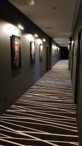 a hallway with paintings on the walls and a long hallway at Sterkh Hotel in Yakutsk