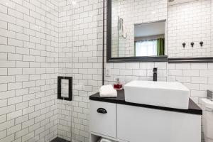 a white bathroom with a sink and a mirror at Le Coureur Des Bois in Quebec City +19 photos