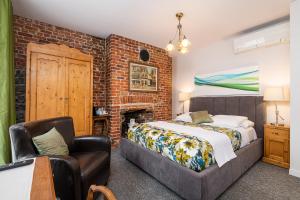 a bedroom with a bed and a brick wall at Le Coureur Des Bois in Quebec City