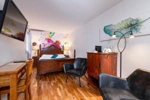 a bedroom with a bed and a desk and a chair at Le Coureur Des Bois in Quebec City