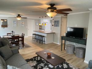 a living room with a couch and a tv and a table at Gorgeous Seaside Seashell Cottage! in Hudson