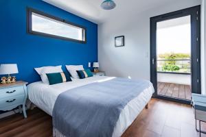 Dormitorio azul con cama y ventana grande en Frenchyhomes☆villadeluxe☆Plage☆piscine en Andernos-les-Bains