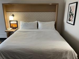 ein großes weißes Bett in einem Hotelzimmer mit Telefon in der Unterkunft Holiday Inn Great Falls-Convention Center, an IHG Hotel in Great Falls