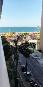 uma vista para uma rua com uma palmeira e o oceano em Clarke's Landscape Apartment 303 Gold B Nascente Sombra em Fortaleza