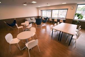 舞鶴市にあるGATEWAY MAIZURUのテーブル、椅子、ソファが備わる客室です。