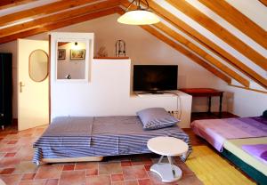 1 dormitorio con 1 cama, escritorio y TV en A2 - studio with balcony just 3 min to the beach en Donji Okrug