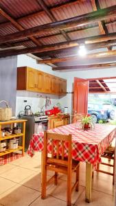 a kitchen with a table with a red and white checkered table cloth at Casa de Campo Villa Marcara in Marcará