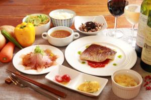 a table with plates of food and glasses of wine at Tanegashima Minshuku Hapisuma in Minamitane