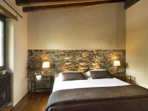 a bedroom with a large bed and a stone wall at Ai Torchi Vecchi in Fivizzano