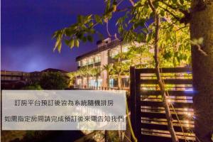 a sign in front of a building at night at Gu-Ji Gu-Ji Garden B&B in Luodong