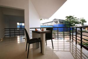 a balcony with a table and a chair on a balcony at Railview Residency in Alleppey