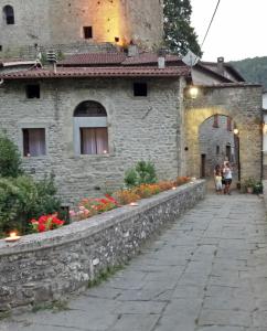 a stone building with people walking in front of it at Mia Casa in Verrucola in Fivizzano