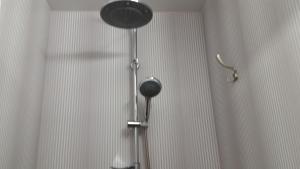 a shower in a bathroom with a shower curtain at Baltā Studio with Patio & Free Parking in Ventspils