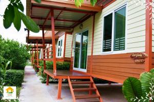 a house with a bench on the side of it at นงนุช โฮมสเตย์ & รีสอร์ท บุรีรัมย์ in Buriram