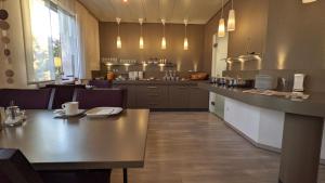 una sala da pranzo con tavolo e una cucina di Hotel Rotes Ross a Erlangen