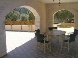 a patio with a table and chairs and a balcony at Stratos Villas in Kaloniktis