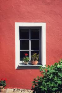 una ventana con tres macetas en una pared roja en Little Vintage, en Frankenberg