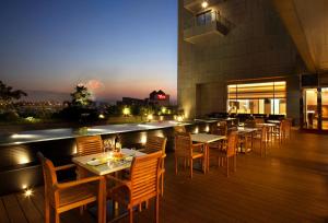 a restaurant with tables and chairs on a deck at night at Park City Hotel - Luzhou Taipei in Taipei