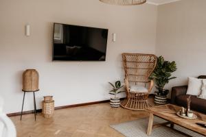 een woonkamer met een bank en een tv aan de muur bij Ferienhaus Olive in Winterberg