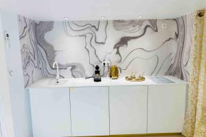a kitchen with white cabinets and a mural on the wall at L’adoré Sainte Catherine in Bordeaux