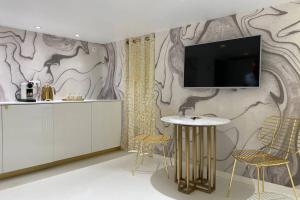 a living room with a tv on a wall at L’adoré Sainte Catherine in Bordeaux