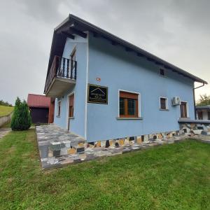 a blue house with a sign on the side of it at Apartma Ksela in Mala Nedelja