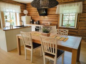 a kitchen with a wooden table and chairs at Hellamaa Retrovisiit Alma & Vilma in Hellamaa