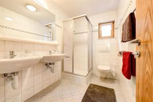 łazienka z 2 umywalkami, prysznicem i toaletą w obiekcie Apartment Fritz w mieście Dalaas