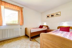sypialnia z 2 łóżkami i oknem w obiekcie Apartment Fritz w mieście Dalaas