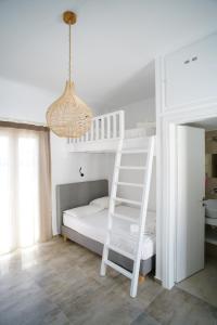 a white bunk bed with a ladder and a chandelier at anerousa in Loutra