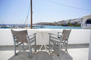 two chairs and a table on a balcony overlooking a harbor at anerousa in Loutra