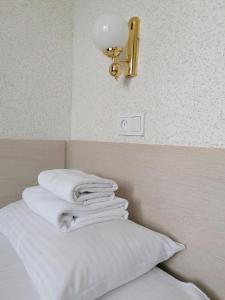 a pile of white towels sitting on top of a bed at Hotel Kolos in Barnaul
