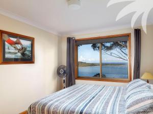 a bedroom with a bed and a large window at Sandbar View in Smiths Lake