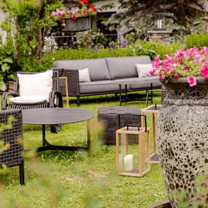 Chesa Valese في زيرمات: حديقة بها أريكة وطاولات وزهور