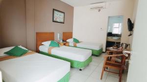 A bed or beds in a room at Helios Hotel Malang