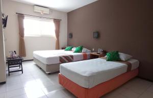 A bed or beds in a room at Helios Hotel Malang