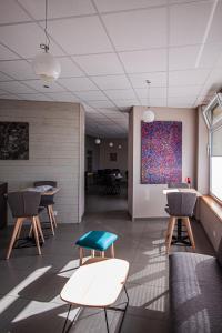 une chambre avec des tables et des chaises et un tableau mural dans l'établissement lhotel, à Thouars