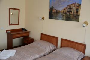 a bedroom with a bed and a desk and a mirror at Burger Plus Inn in Lviv