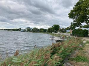 a boat is docked on the side of a river at Lahe koht in Haapsalu