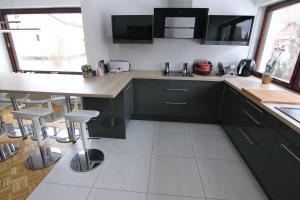 a kitchen with black cabinets and white tile floors at Schönes Familienzimmer in Neumarkt in der Oberpfalz