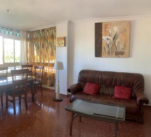 a living room with a brown couch and a table at Turismo Vacacional de Lujo ttluga -Málaga in Cala del Moral