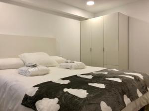 - une chambre avec un lit et une couverture noire et blanche dans l'établissement MonResidence Cavall Bernat, à Manresa