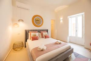 ein Schlafzimmer mit einem großen Bett mit Handtüchern darauf in der Unterkunft Amate Case by Ortigiaapartments in Syrakus