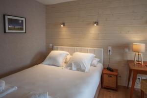 トゥアールにあるlhotelのベッドルーム1室(白いシーツと枕のベッド1台付)