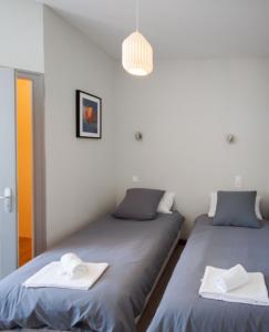 1 dormitorio con 2 camas y toallas. en lhotel en Thouars